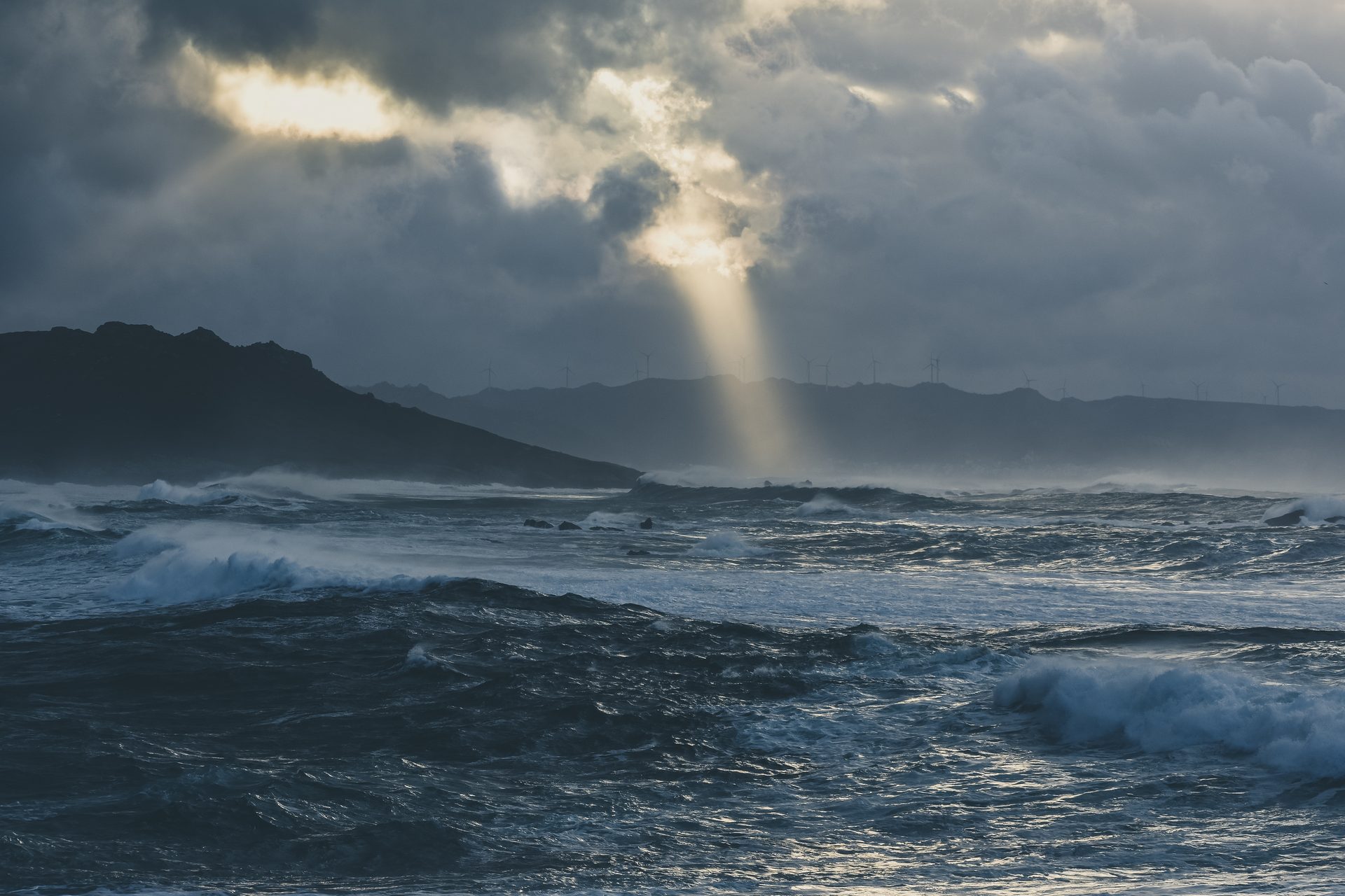 Mar tormentoso con un rayo de luz atravesando las nubes